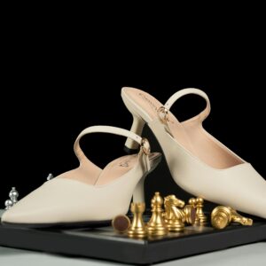 Chic beige high-heeled shoes elegantly placed on a chessboard with golden pieces, perfect for fashion concepts.