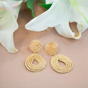 Stylish gold earrings paired with fresh white lily flowers, perfect for fashion and decor.